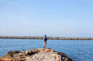 Man fishing off the pier at Corona Del Mar, Newport Beach, California