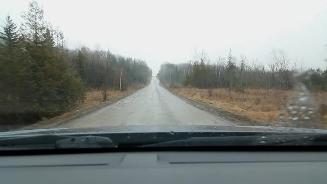 Driving up hill on wet, muddy road. Rural Ontario. Rain falling. Driving south on Blezard Line in Indian River, Ontario.