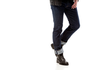 Naklejka premium partial view of stylish man wearing denim and leather boots isolated on white