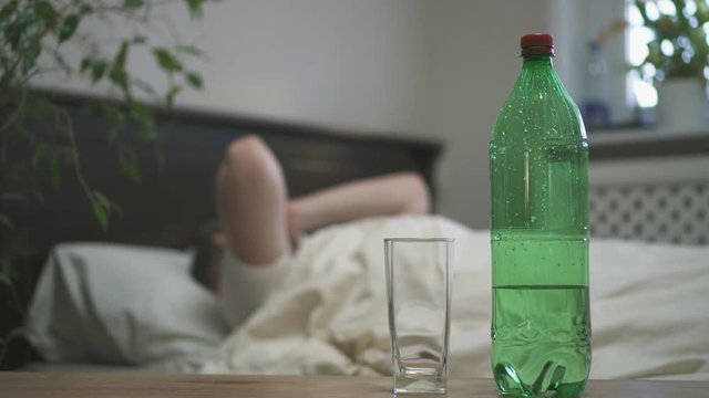 Man drinking mineral water and suffering from hangover.