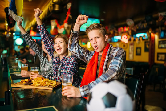 Fans celebrate victory at counter in sports bar