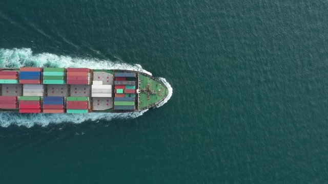 Container ship in export and import business and logistics. Shipping cargo to harbor by crane. Water transport International. Aerial view and top view.