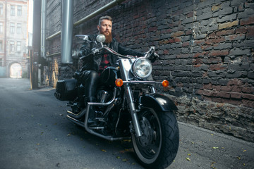 Obraz na płótnie Canvas Bearded motorcyclist on classical chopper, biker
