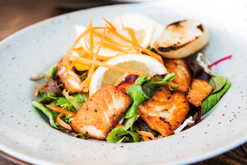 grilled salmon and lemon - french cuisine dish with tomato and salmon