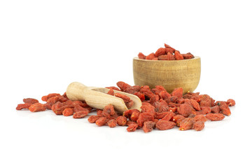 Lot of whole dried red goji berries light scoop with wooden bowl isolated on white background