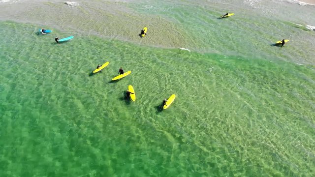 Aerial approaching top down view on surfers in Northern Sea in Norway on a sunny day