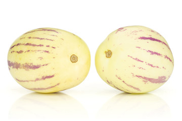 Group of two whole ripe light yellow fresh striped pepino melon isolated on white background