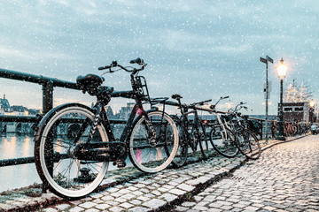 Fototapeta premium Winter view of parked bicycles alongside the Dutch river Maas