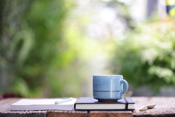 vintage blue cup and notebook on wooden table