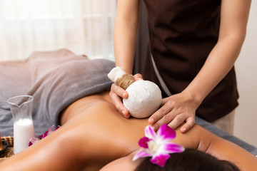 Obraz na płótnie Canvas Masseur doing back massage with compress in spa salon. Beauty treatment concept.