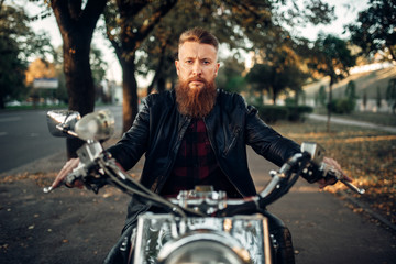 Fototapeta na wymiar Bearded motorcyclist sitting on classical chopper