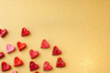 Valentine's day concept. gift for Valentine's Day, a red box with sweet hearts on a gold background. Pictures of Love. selective focus