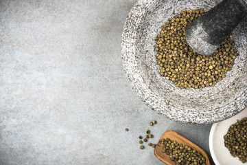Green peppercorn seed in granite mortar or pestle