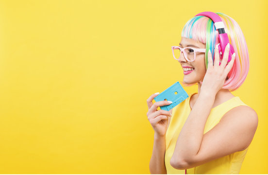 Woman with cassette tape and bright colorful wig on a yellow background