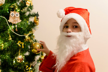 Merry Christmas holidays Santa boy near beauty fir tree
