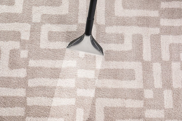 Removing dirt from carpet with vacuum cleaner in room, top view