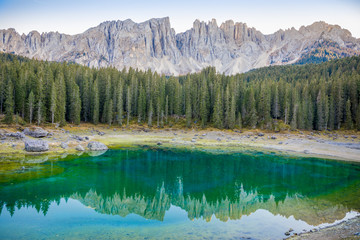 Karersee or Lago di Carezza, is a lake with mountain range of the Latemar group on background in the Dolomites in Tyrol, Italy