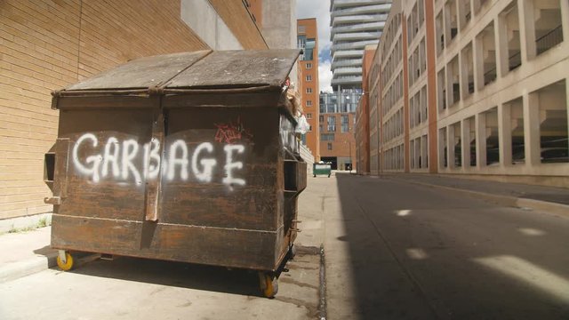 Garbage bin with flapping plastic and flies. Toronto, Ontario, Canada.