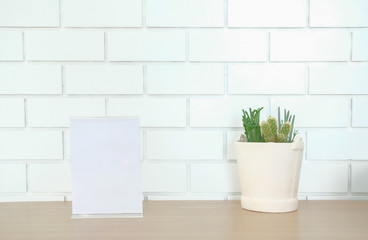 white label in cafe. display stand for acrylic tent card near white brick wall. mockup menu frame on table in restaurant.
