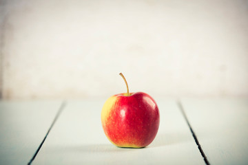 Apple on white wooden background, space for text