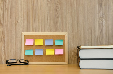 sticky notes reminder on cork board & book. education workspace concept