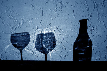 wine bottle and two glasses shadow in blue