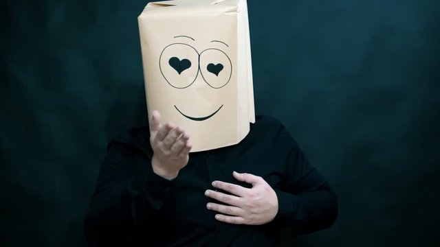 The concept of emotions. A man his fingers depicts a shape of a heart. Looks lovers eyes. Air kiss. On the face smile and happiness.