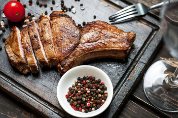 Grilled New York steak with salt and pepper on a dark wooden background