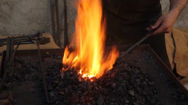 Heating the iron in a smithy.