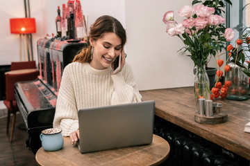 Busy woman working remotely from a cafe