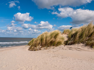 Mit Gras bedeckte Düne vor der Nordsee am Strand in Niew Hamstede auf der Insel Walcheren in den Niederlanden