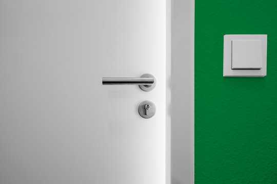 offene Tür mit Lichspalt und grüner Wand
