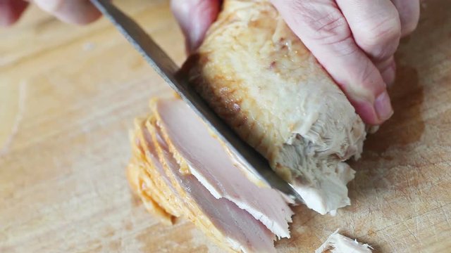 A Man Slices A Roast Turkey Breast