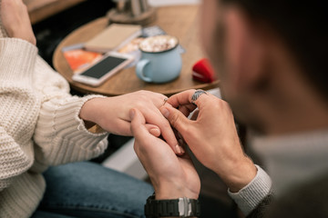 Obraz na płótnie Canvas Man putting a ring on his girlfriends finger