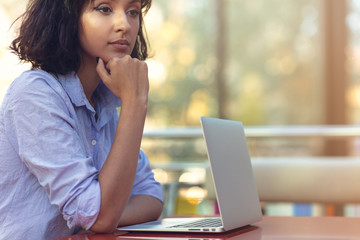 Stressed hipster businesswoman working on laptop in her office