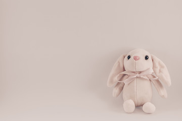 postcard with sitting toy pink rabbit on a white background
