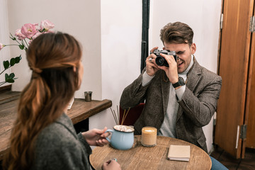 Man is taking a picture of woman using film camera