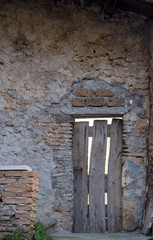 Ancient wooden door in old stones brick wall