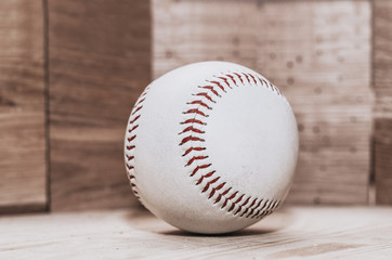 Baseball ball on wooden background. Handmade, Sports. Game inventory. Manufacture of wood and leather.