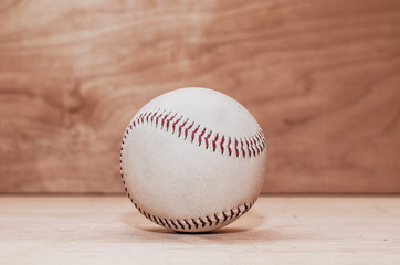 Baseball ball on wooden background. Handmade, Sports. Game inventory. Manufacture of wood and leather.