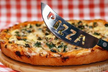 Appetizing pizza and knife, close-up
