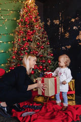 Obraz na płótnie Canvas happy family with a child celebrate the new year near the Christmas tree