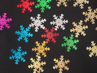 Colorful shiny stars on a black background. Winter background.