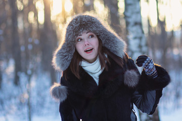 Woman in fur hat in winter park. People
