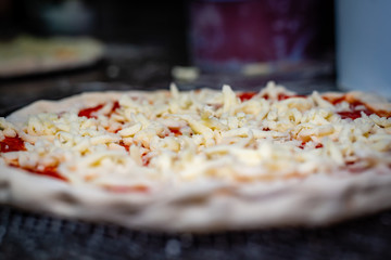 A raw pizza prepared to be cooked in the oven, closeup