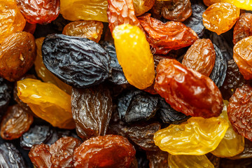 Assortment of Raisins, yellow, blue, black, golden raisin on dark background. Healthy snack, dietary product for good life. Food background and texture, Vega Food. Close-up image. Macro.