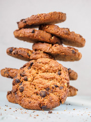 Chocolate chip cookies on white background. Stacked chocolate chip cookies on brown napkin. Symbolic image with place for text. Freshly baked. Concept for a tasty snack. Sweet dessert. Selective focus