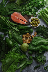 Fresh healthy food: vegetables, greens, fruits, walnuts and raw salmon steak. Flatlay composition, top view. Healthy food ingredients concept.