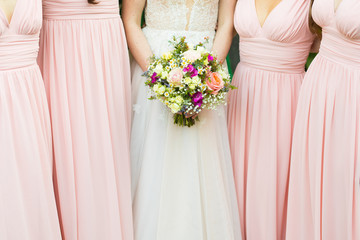 bride with wedding bouquet from pink roses and camomiles