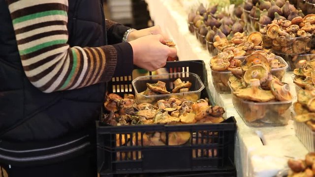 Cleaning mushrooms in a market. La Boqueria market. Barcelona, Catalonia, Spain.